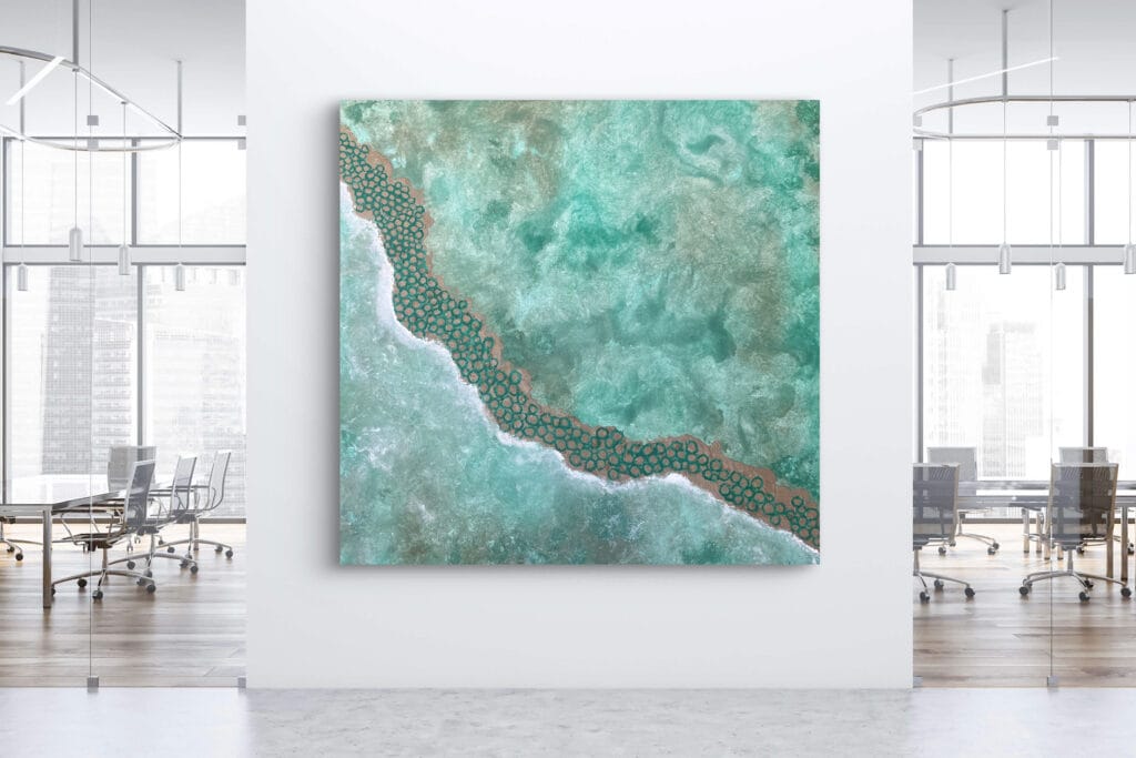 This image shows a large contemporary abstract painting (159 x 159 cm) titled The Beach as Ambition, displayed in a modern bright office space. The artwork features turquoise, aqua, and sandy tones created with French pigments and Gumbaynggirr Country sand. Artwork available for AUD 5100.
