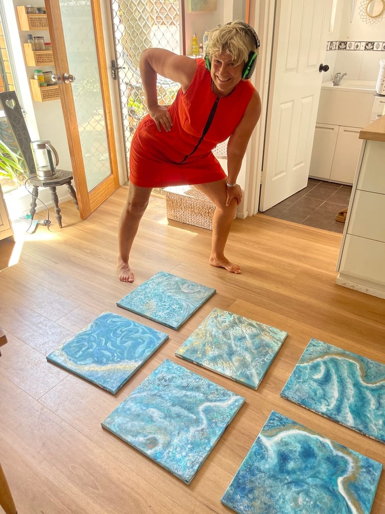 Artist Janet Besancon at home with some smaller wall art works showing the sea ad coast with 'buv bbling' waves set on the floor. These artworks will be part of her art exhibition called "Je bulle librement', which means "I bubble freely" in English, to be shown from December 10th- 23rd 2025 in Coffs Harbour Central Plaza on the Mid North Coast of NSW Australia.